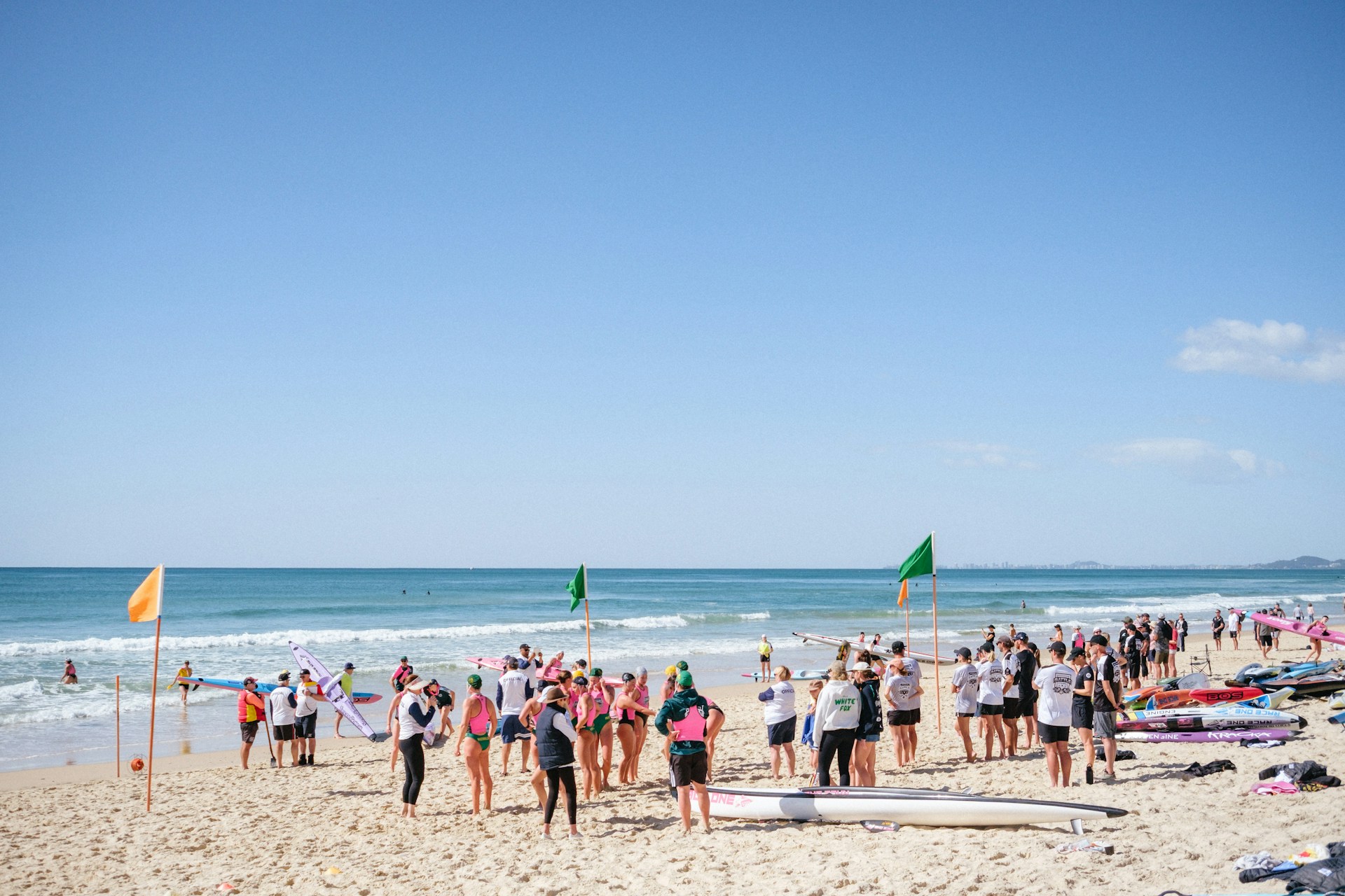 Masa ljudi na plaži pored zastava
