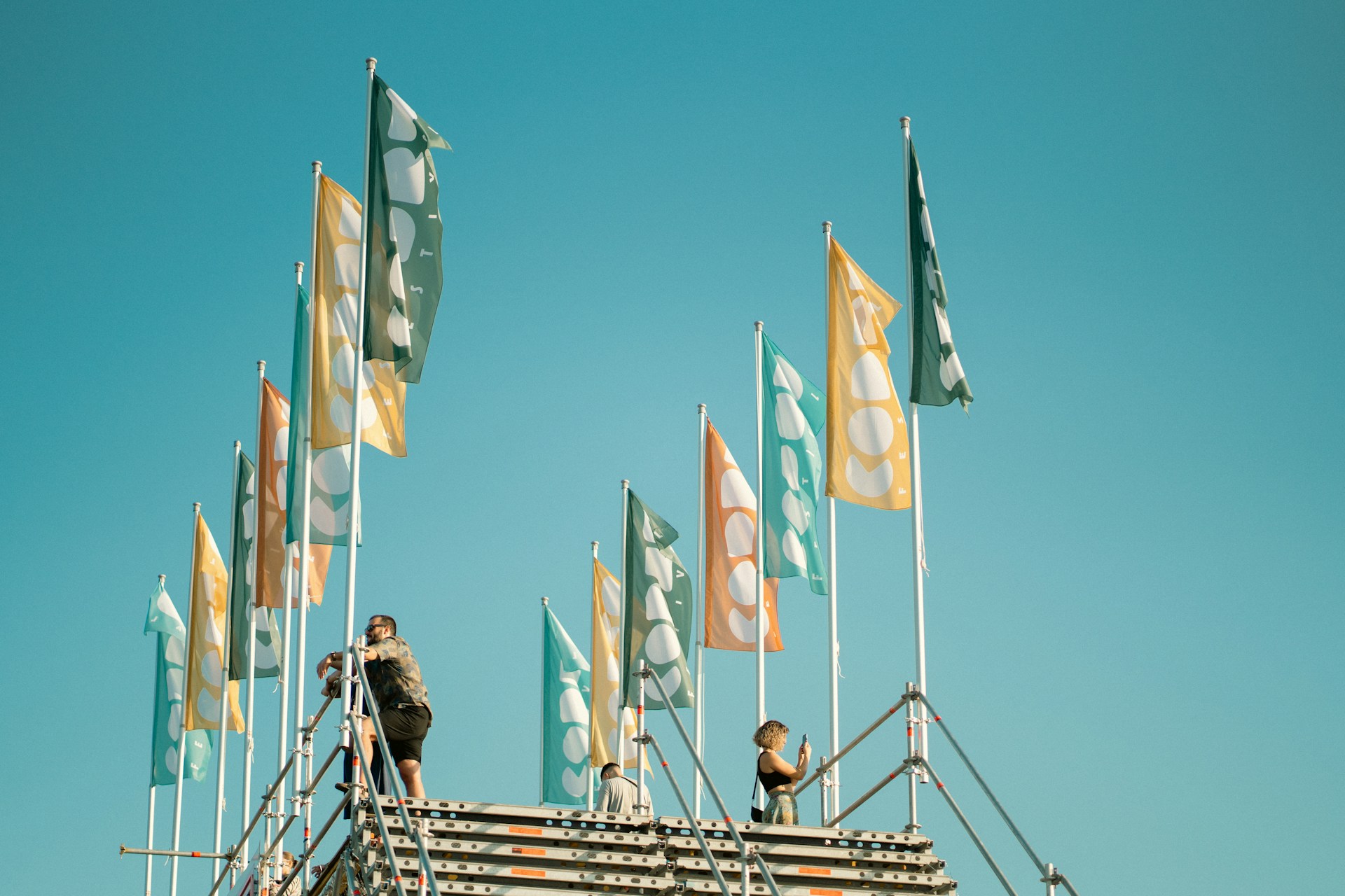 Dve osobe stoje ispod zastava na  plaži